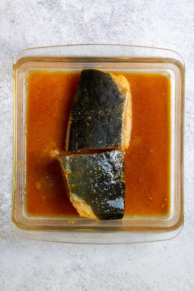 fish fillets marinating in a shallow dish.