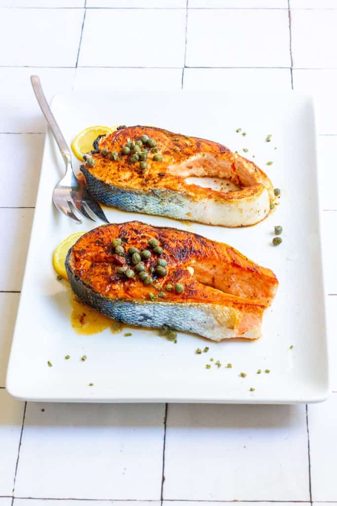 pan-seared salmon steaks on a serving tray.