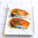 pan-seared salmon steaks on a serving tray.