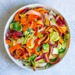 bowl with carrots, sprouts and fruit tossed together.