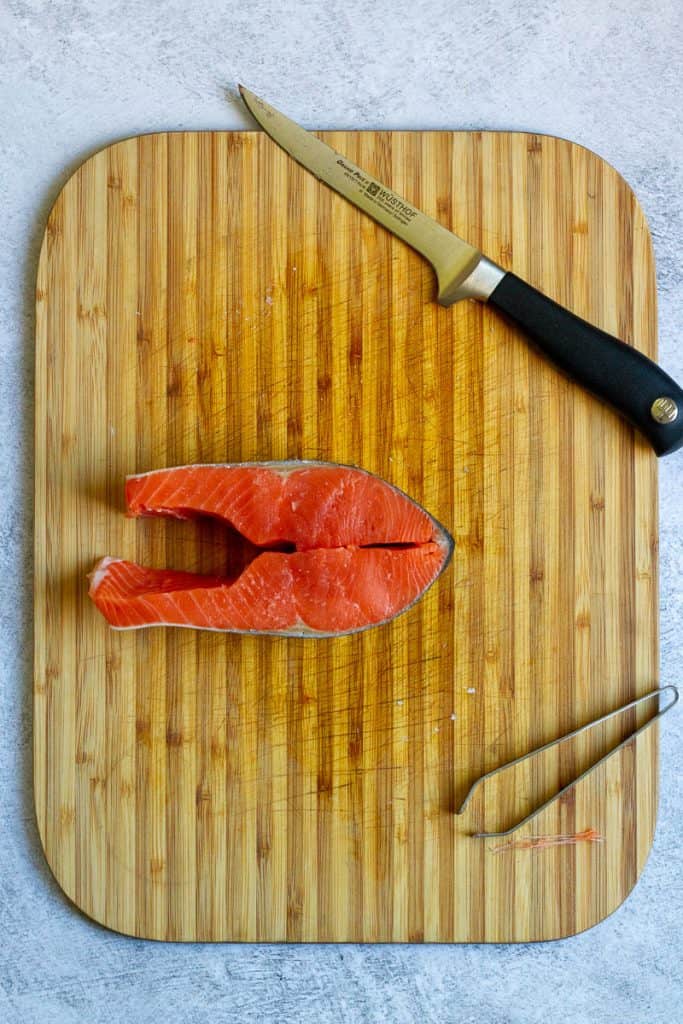To Debone Salmon Steak, Use Boning Knife + Tweezers on Cutting board.