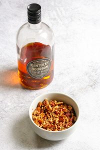 bowl of chopped pecans with bourbon.