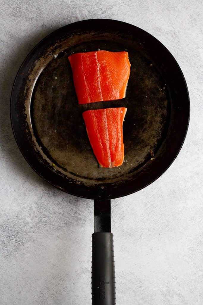 salmon skin-side down in a pan.