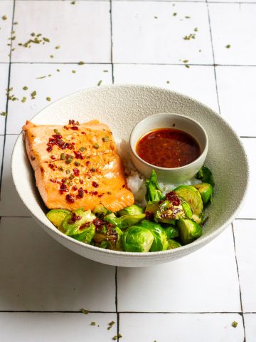 sweet and sour salmon with brussels sprouts and rice in a bowl.