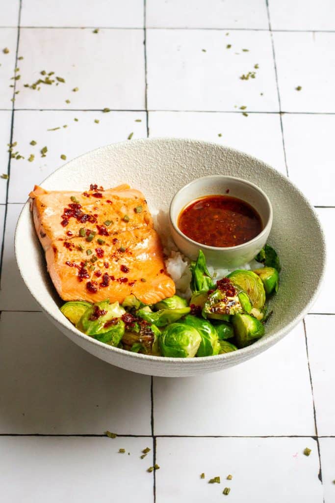 sweet and sour salmon with brussels sprouts and rice in a bowl.