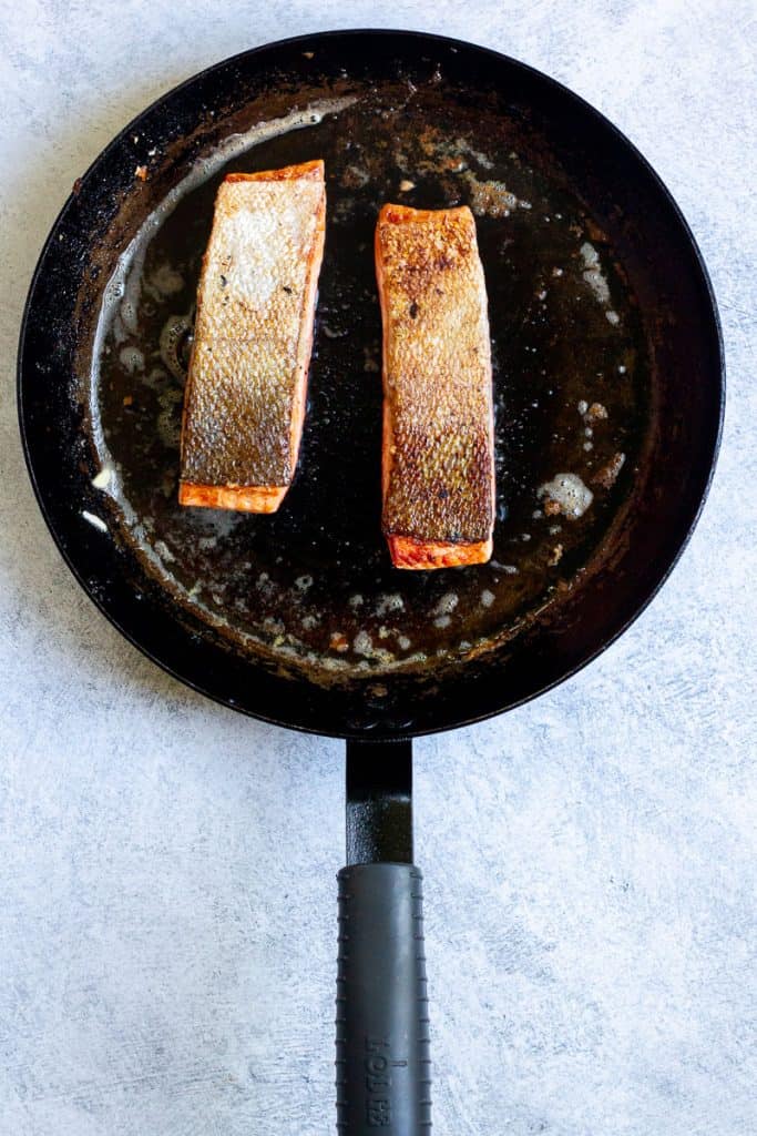 trout flipped over in the pan, skin-side up.