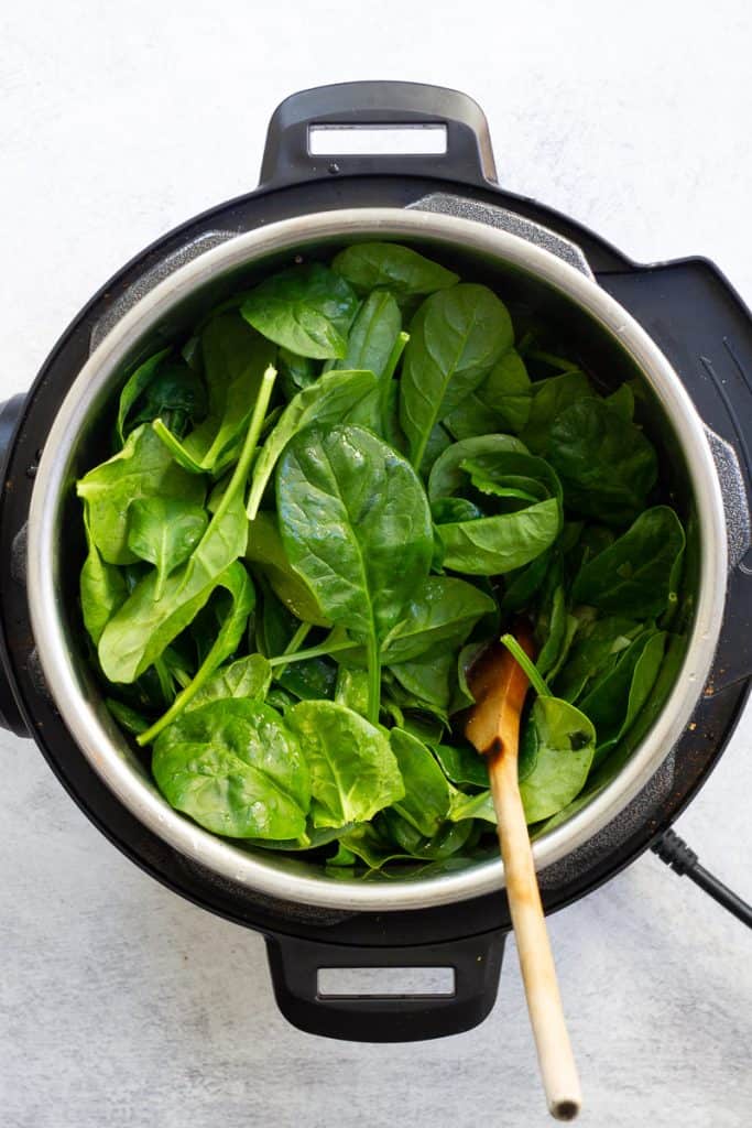 Fresh spinach added to pot.