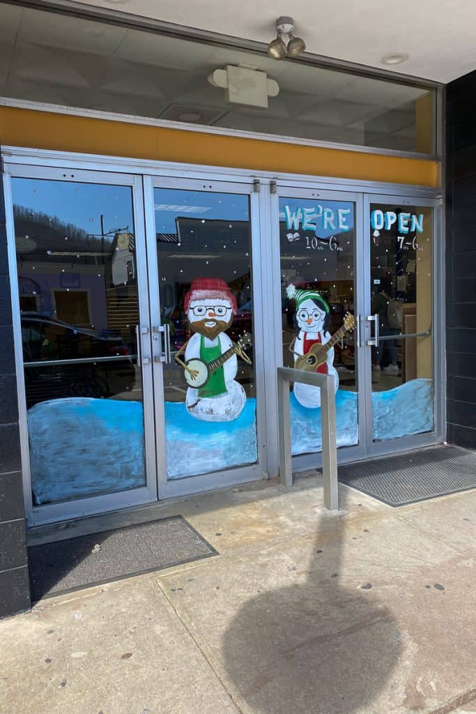 Front doors of Fuzzy Duck Coffee Shop with snowmen painted on them.