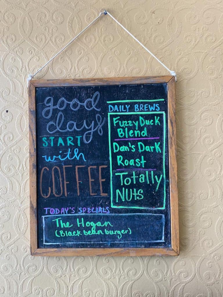 Sign with daily coffee brews and specials listed at Fuzzy Duck Coffee Shop.