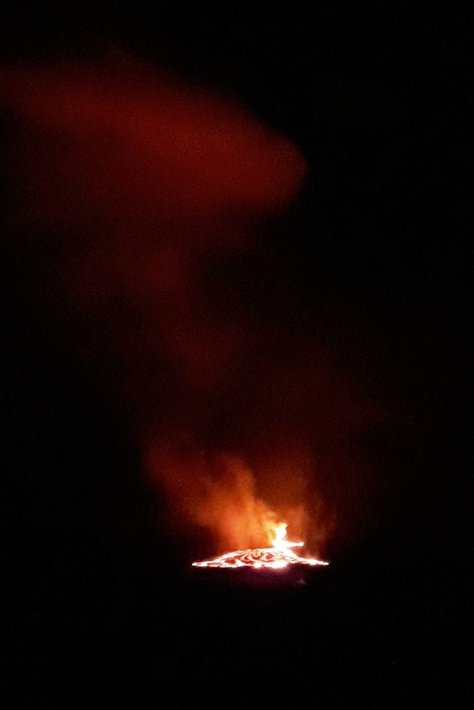 Fiery lava flow at night in Hawaii Volcanoes National Park.