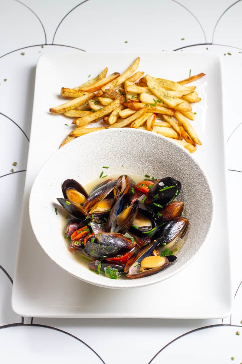 beer mussels on a serving platter with fries.