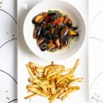beer mussels on a serving platter with fries.