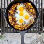 Campfire hash with eggs, potatoes and chorizo in skillet.
