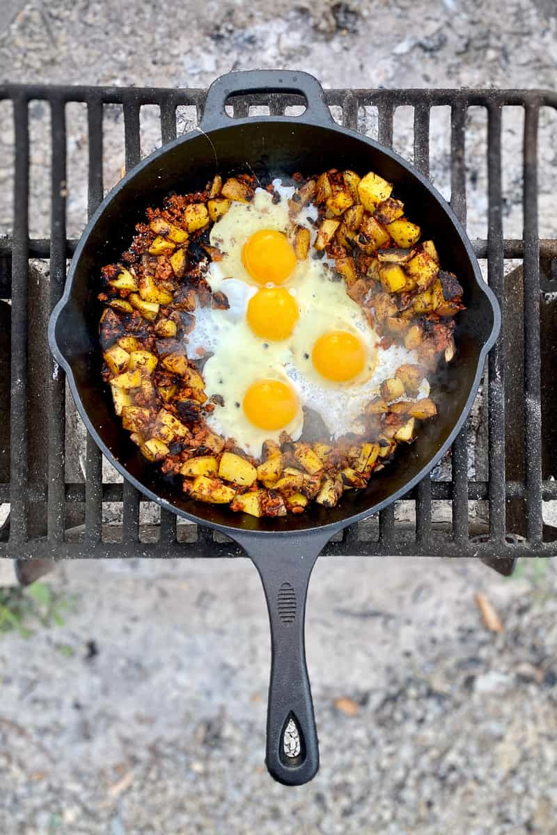 Campfire breakfast hash with eggs, potatoes and chorizo in skillet.