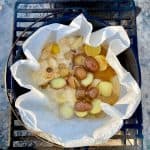 Potatoes, beer, onion, lemon, and seasoning in parchment lined Dutch oven.