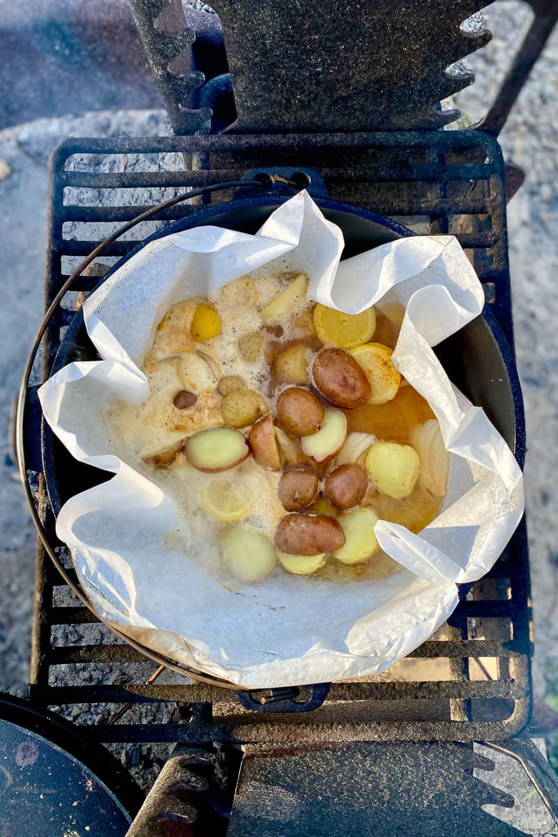 Potatoes, beer, onion, lemon, and seasoning in parchment lined Dutch oven.
