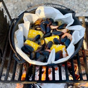 Mussel, shrimp, corn, and potato mixture cooked in Dutch oven.
