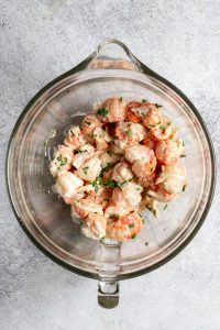 langostino tails mixed with mayo and chives in a bowl.