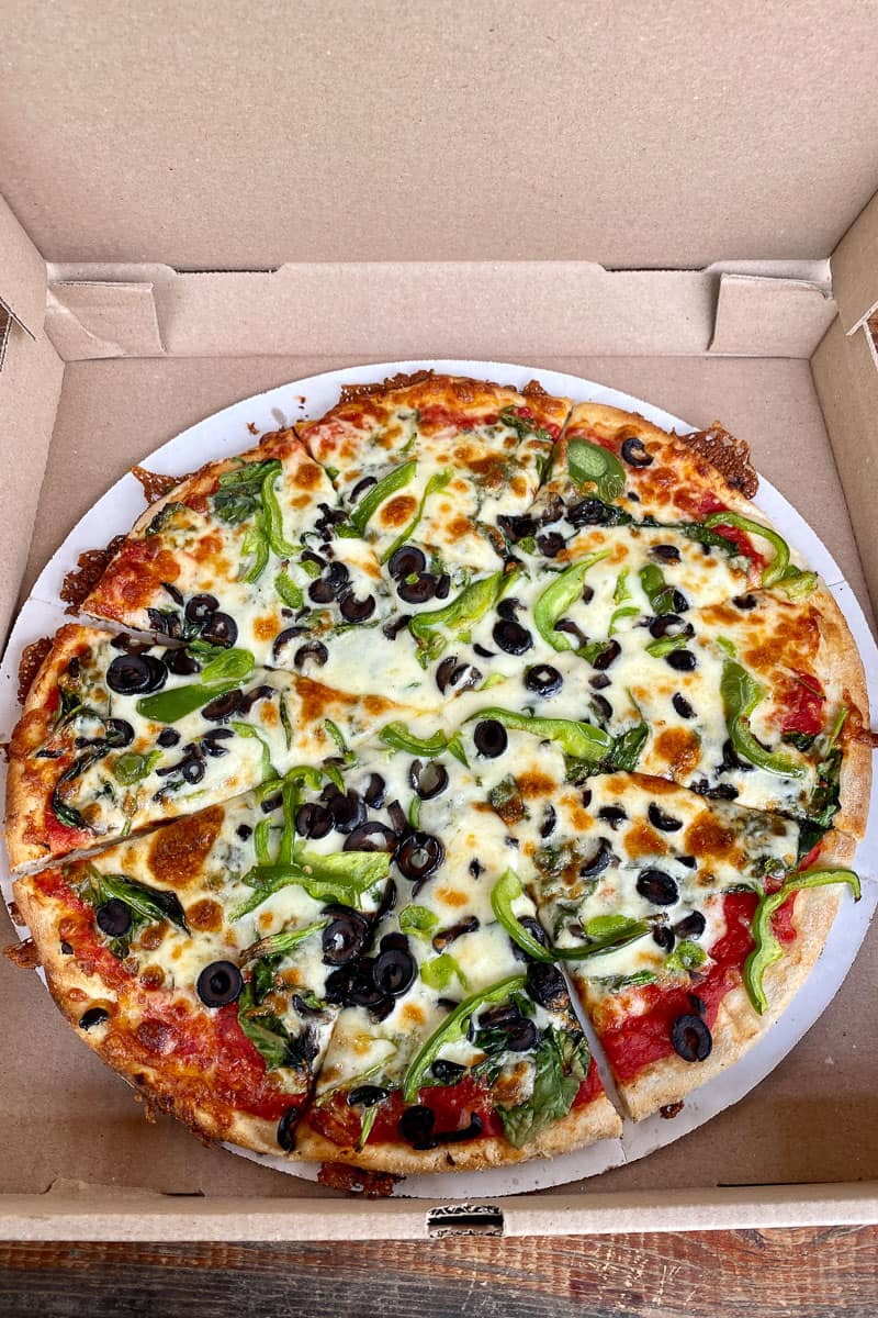 Veggie pizza with spinach, bell pepper and olives.