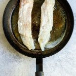 floured hake in a pan.