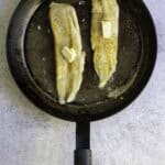 hake in pan, topped with butter.