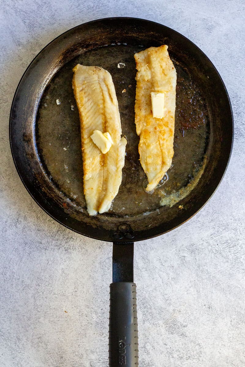 fish with butter in a pan.