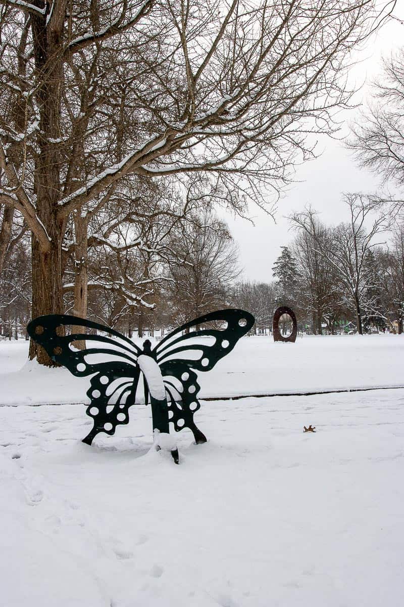 butterfly sculpture in snowy park.