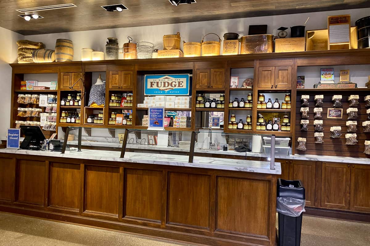 Fudge shop with wooden shelves displaying products for sale.