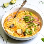Fish coconut curry in bowl with spoon.
