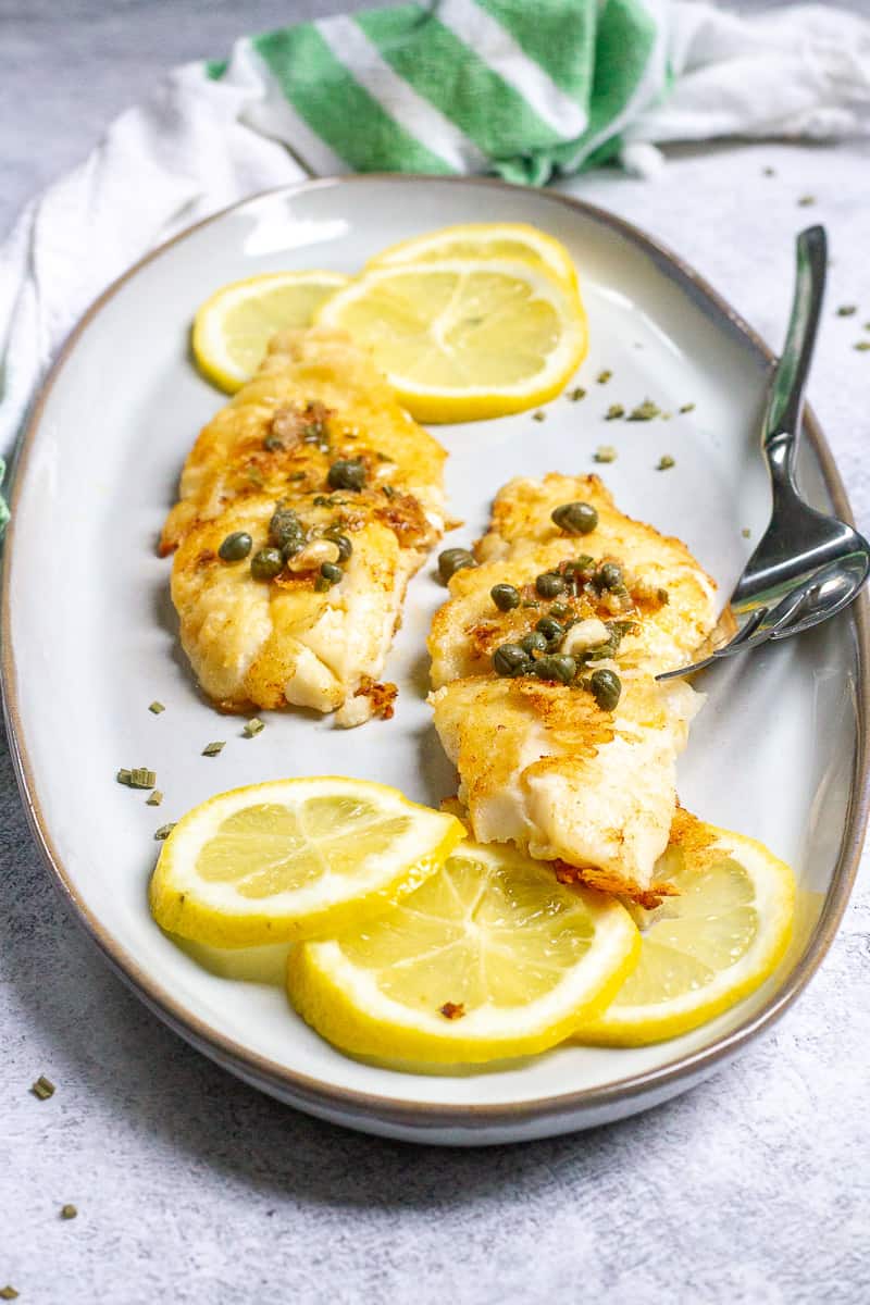 Pan-seared orange roughy with a lemon caper sauce served on a plate.