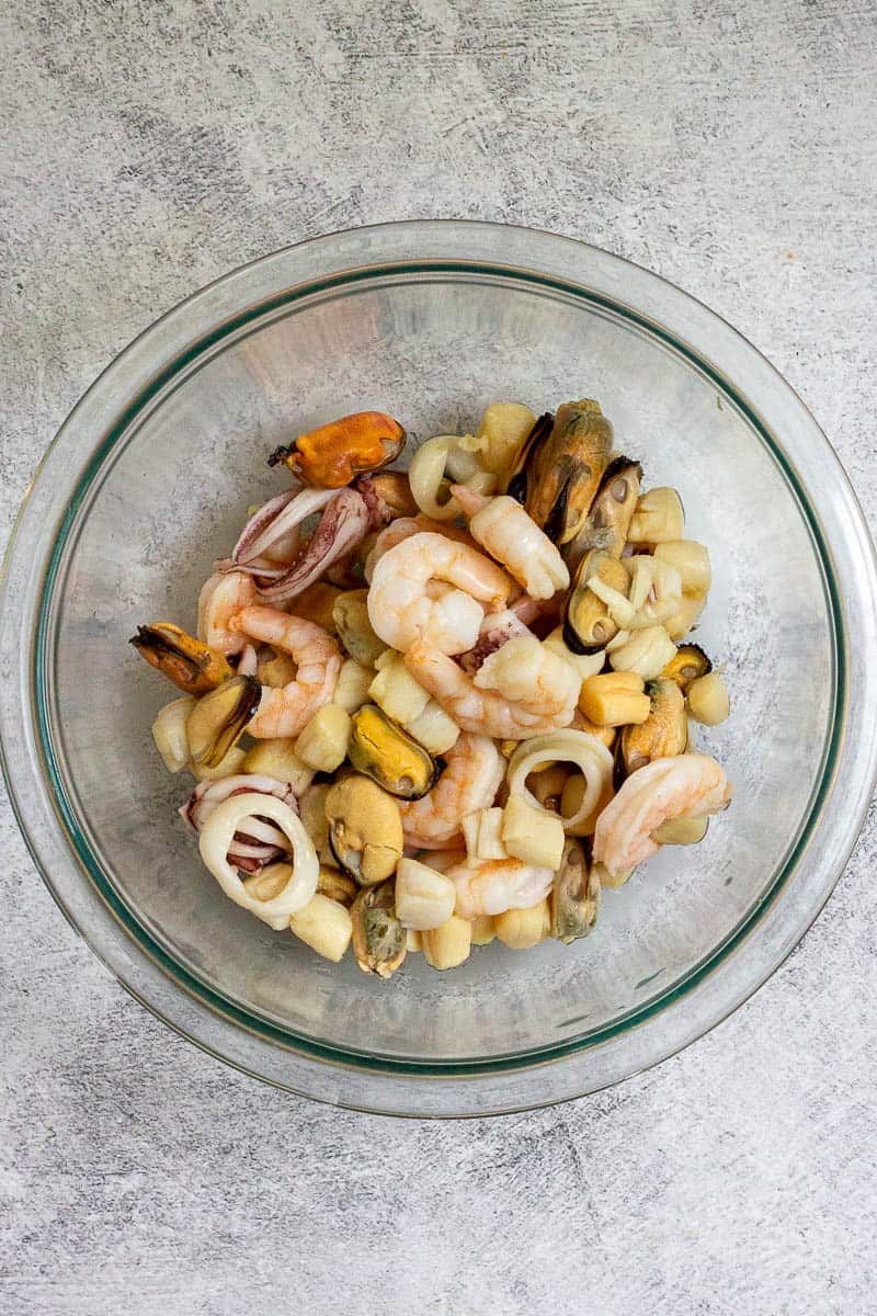 Seafood mix of shrimp, mussels, scallops and calamari in bowl.