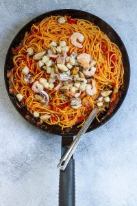 Add seafood mix to cooked pasta and sauce in skillet.