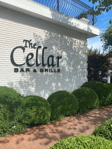 Side of building with lettering saying "The Cellar Bar and Grille."