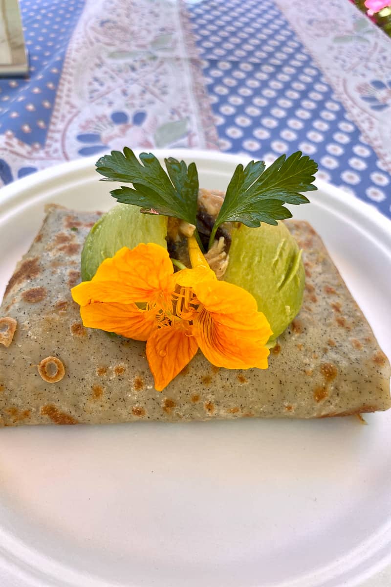 Chicken and mushroom crepe with yellow flower on top.