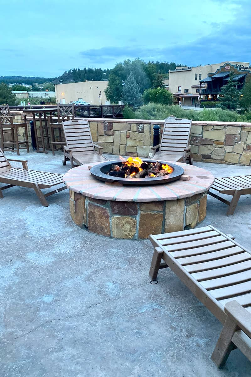 Fire pit in the relaxation terrace with lounge chairs around it.