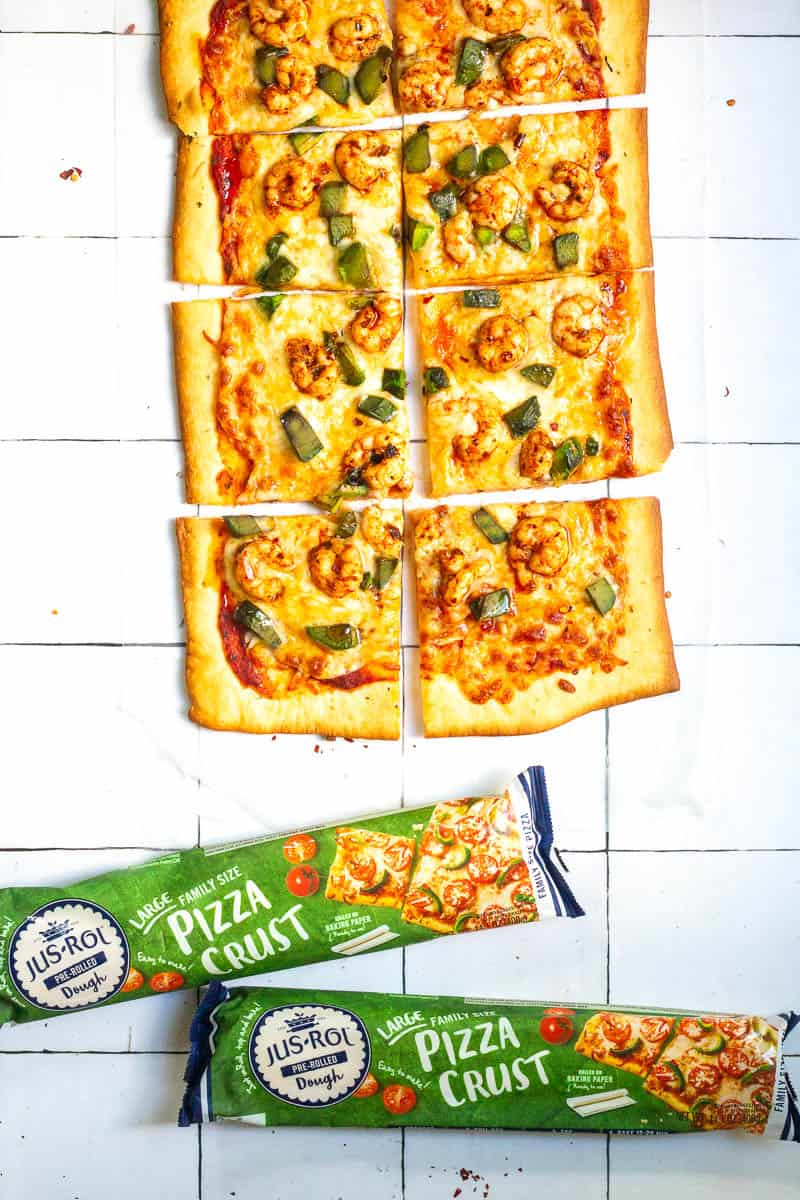 Spicy shrimp pizza square slices next to packages of Jus-Rol pizza crust dough.