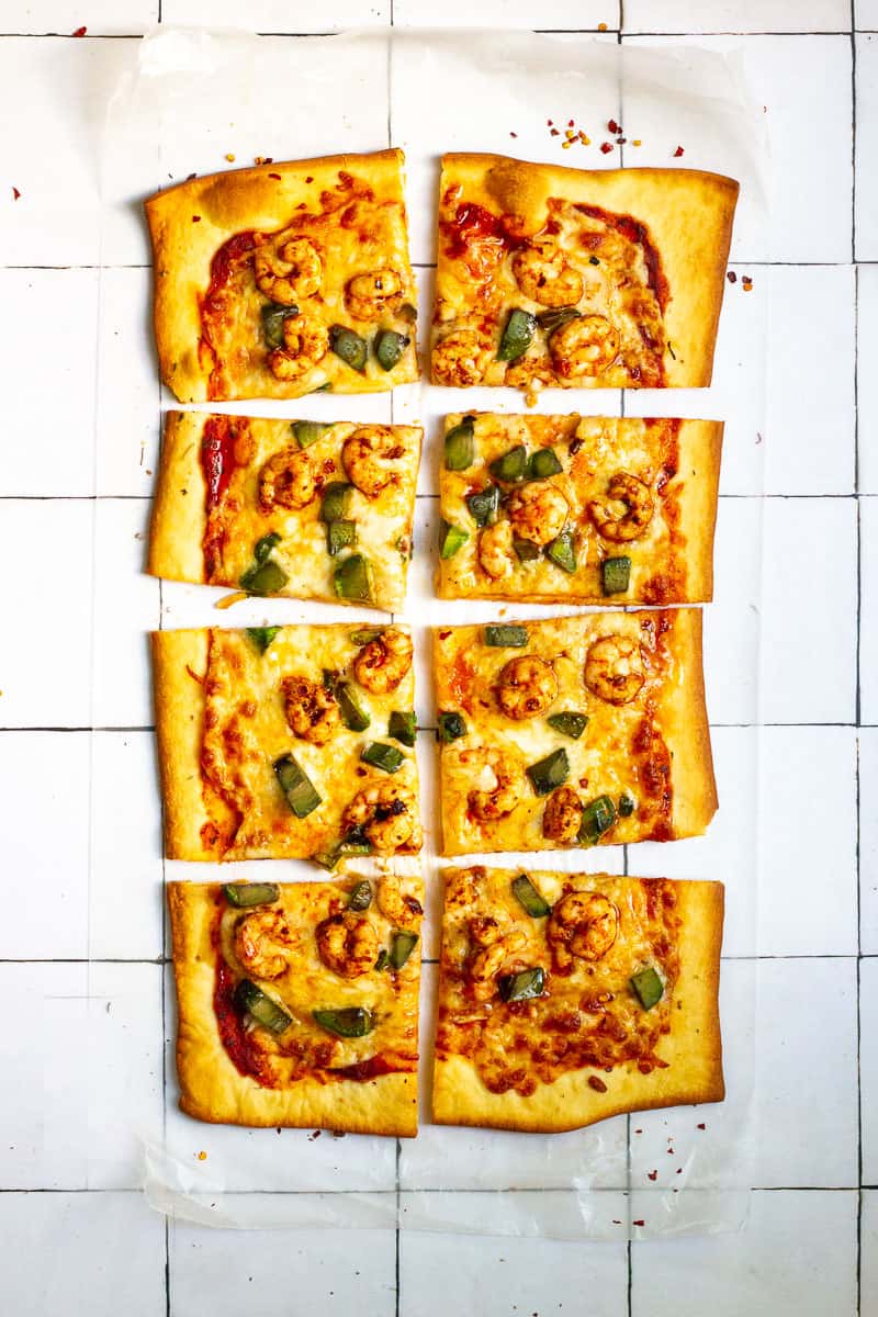 Spicy shrimp pizza cut into 8 square slices.