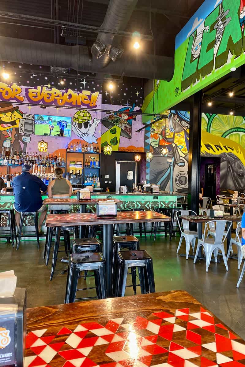 Interior of Condado restaurant with brightly colored murals on walls.