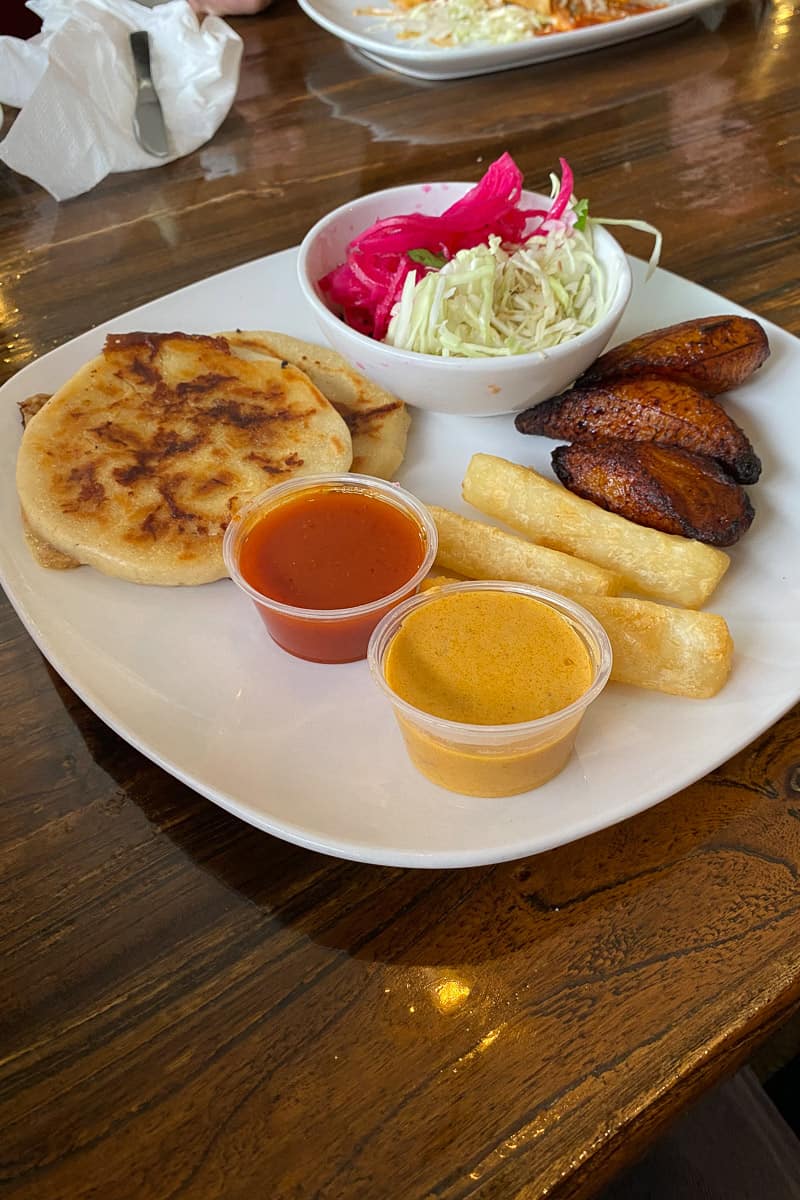 Two corn pupusas, three yucca fries, three plantains, and two cups of sauce.