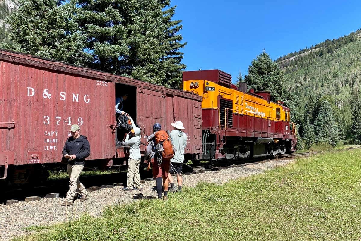 Backpackers loading gear into train car near Elk Park to Needleton hiking loop.