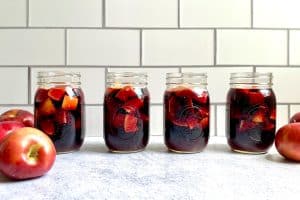 Four mason jars filled with camping apple sangria.