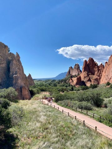 Wide sidewalk through the midst of large spiky red rock formations.