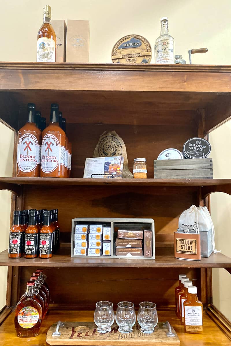 Bourbon hot sauce, honey, maple syrup, and drink mix on shelves.