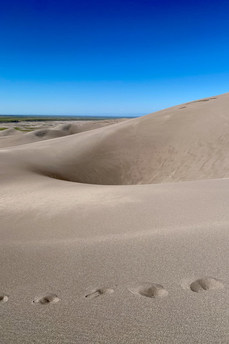Large sand dune at Great Sand Dunes National Park with footprints.