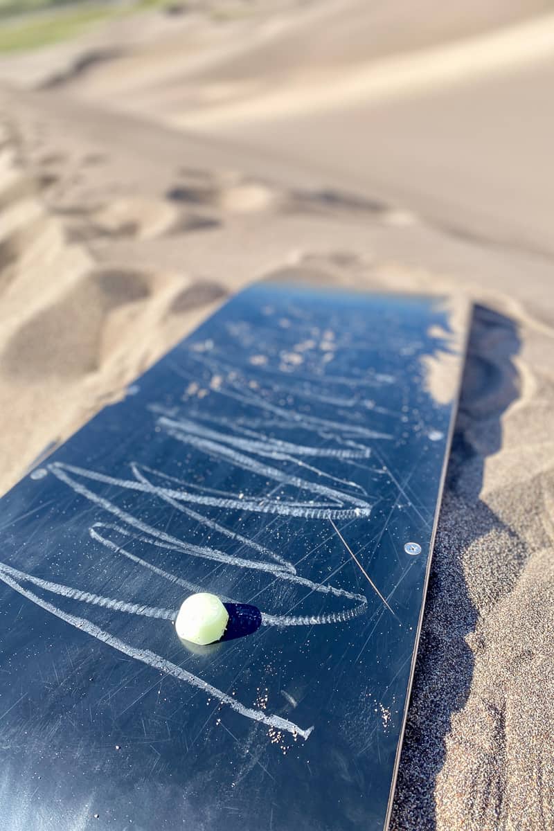 Sandboard with small lump of wax sitting on it.