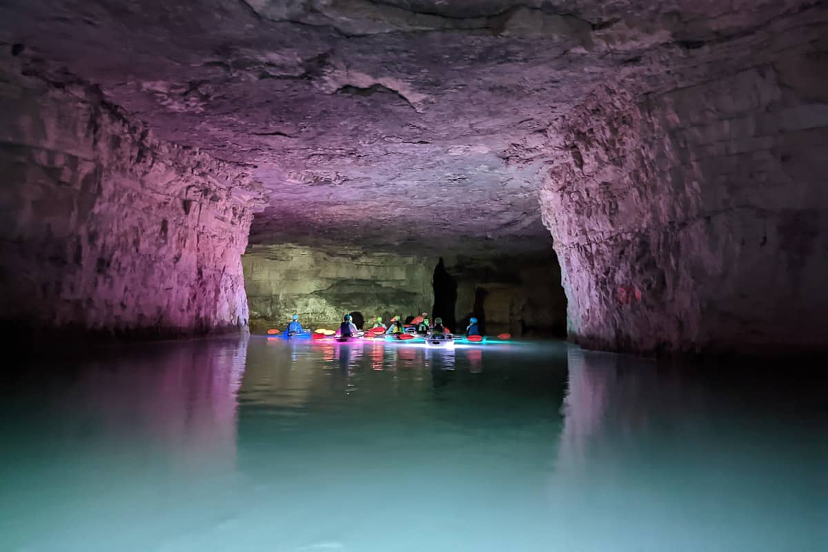 Group of kayakers underground in a flooded mine in red river gorge.
