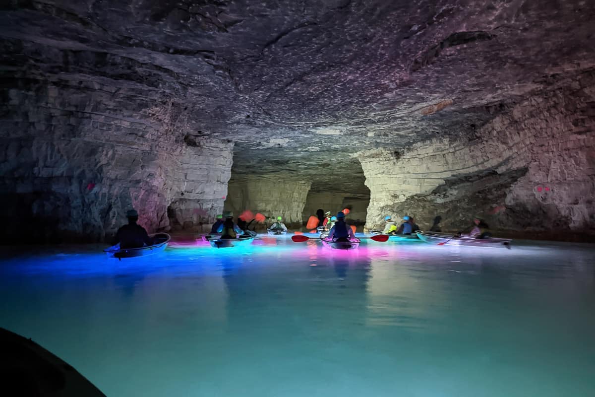 Group of underground kayakers in red river gorge floating in flooded abandoned mine.