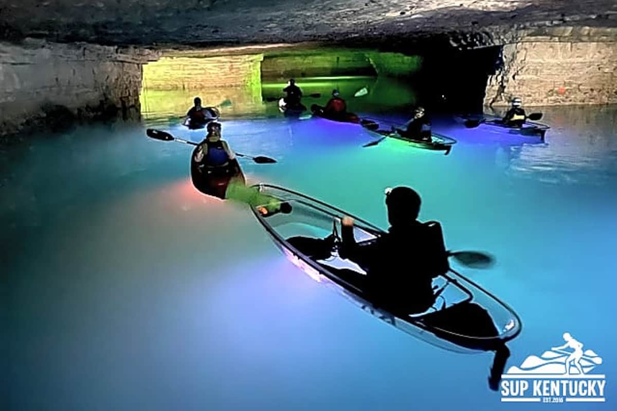 Group of underground kayakers at Red River Gorge in a flooded mine cavern.