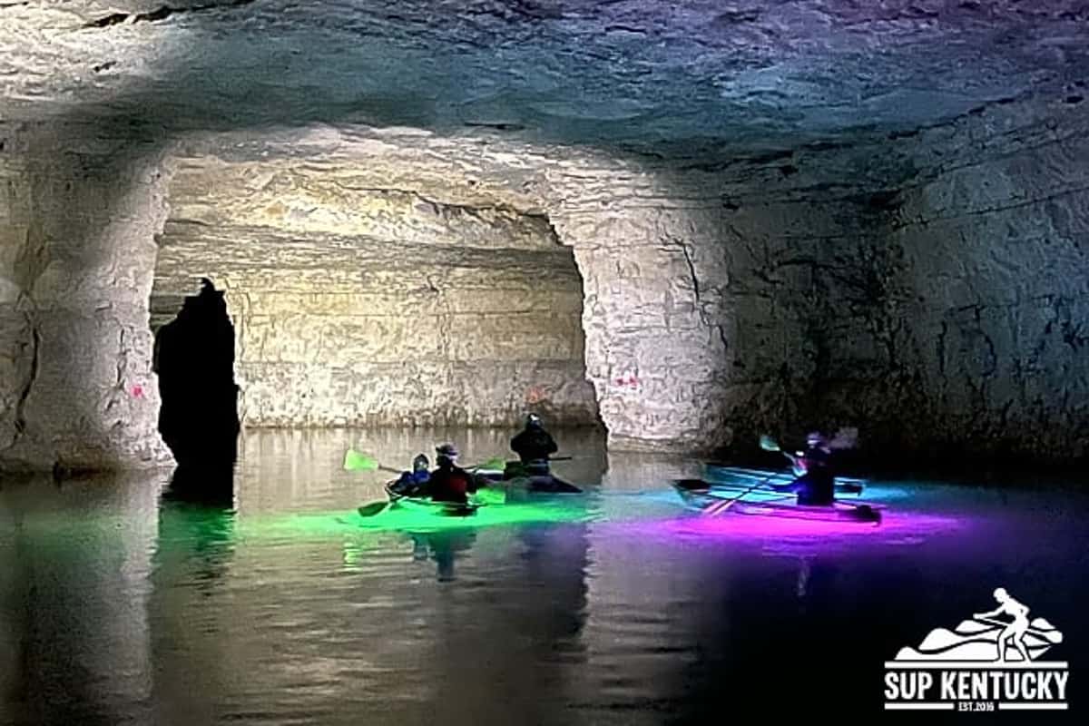 Group of underground kayakers in red river gorge floating in a flooded mine.