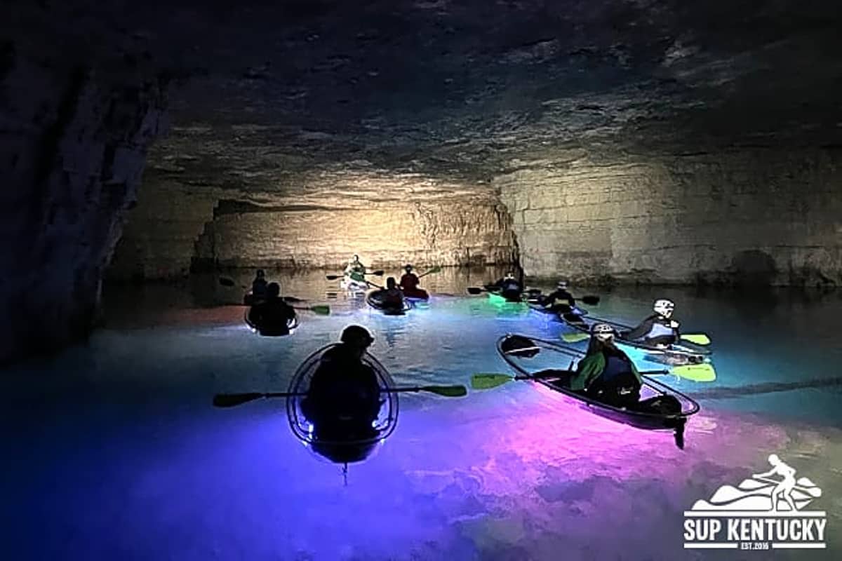 Group of kayakers in red river gorge floating in a flooded mine cavern.